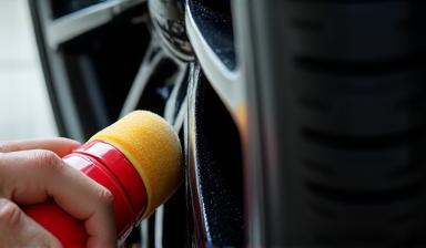 Close up of car tire receiving tire shine application